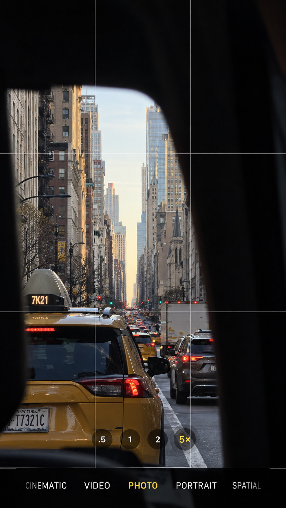 A city avenue and yellow cab seen through a phone camera viewfinder