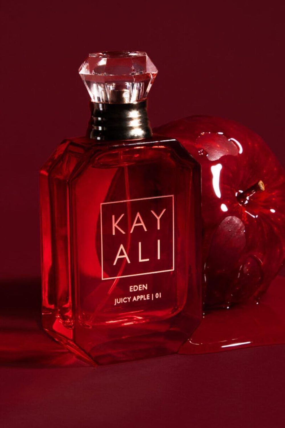 Kayali Eden Juicy Apple | 01 perfume beside a red apple